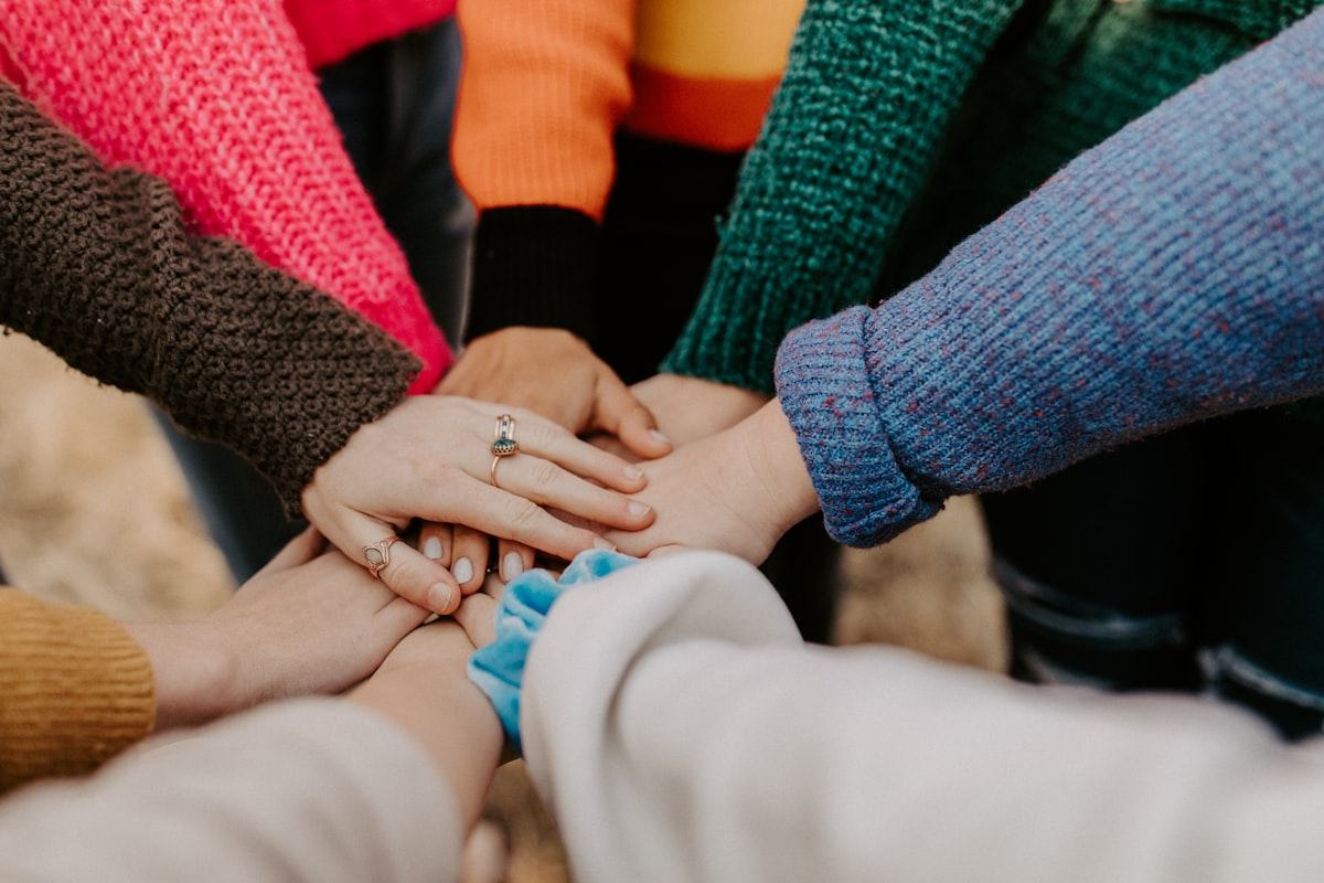 A group of people with their hands stacked together in a circle